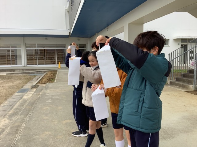 温度計で気温を測っています。